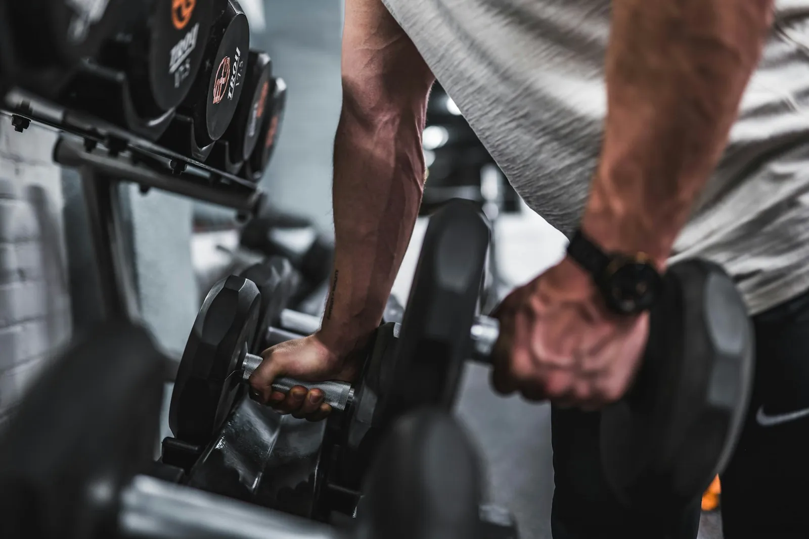 Personal trainer al rack dei manubri