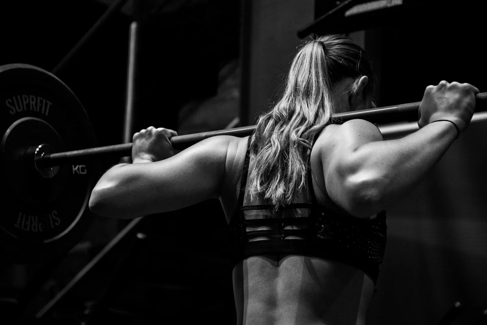 Atleta sotto il bilanciere allo squat rack